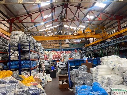 Inside the Delhi facility: racked material and finished goods under an overhead travelling crane